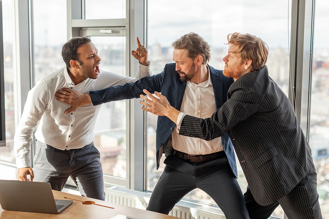 Three Businessmen Involved in Intense Argument in a Modern Office